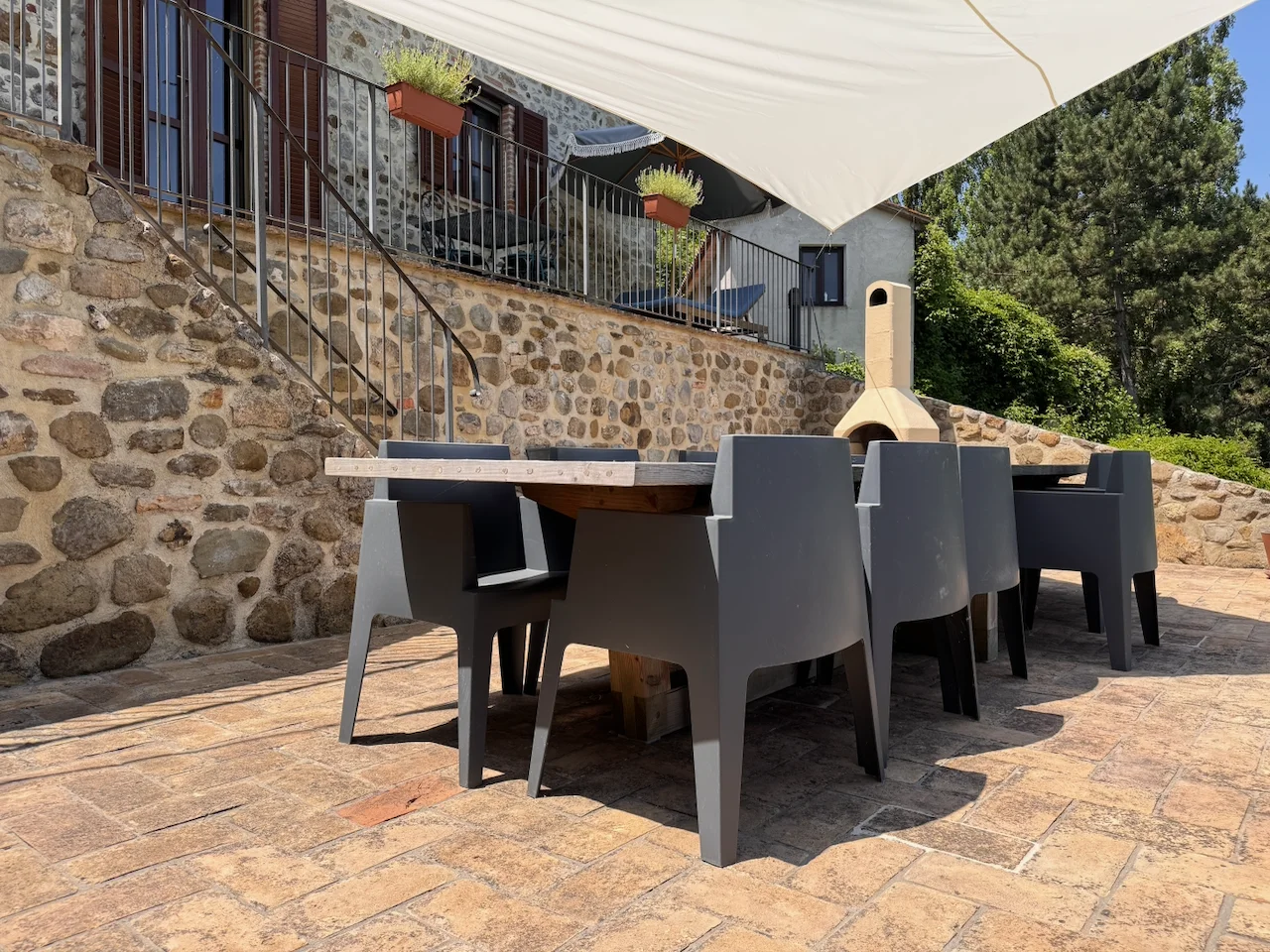 Stone courtyard with outdoor dining and pizza oven